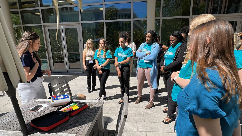 A photo of CCU public health students surrounding lecturer using AED