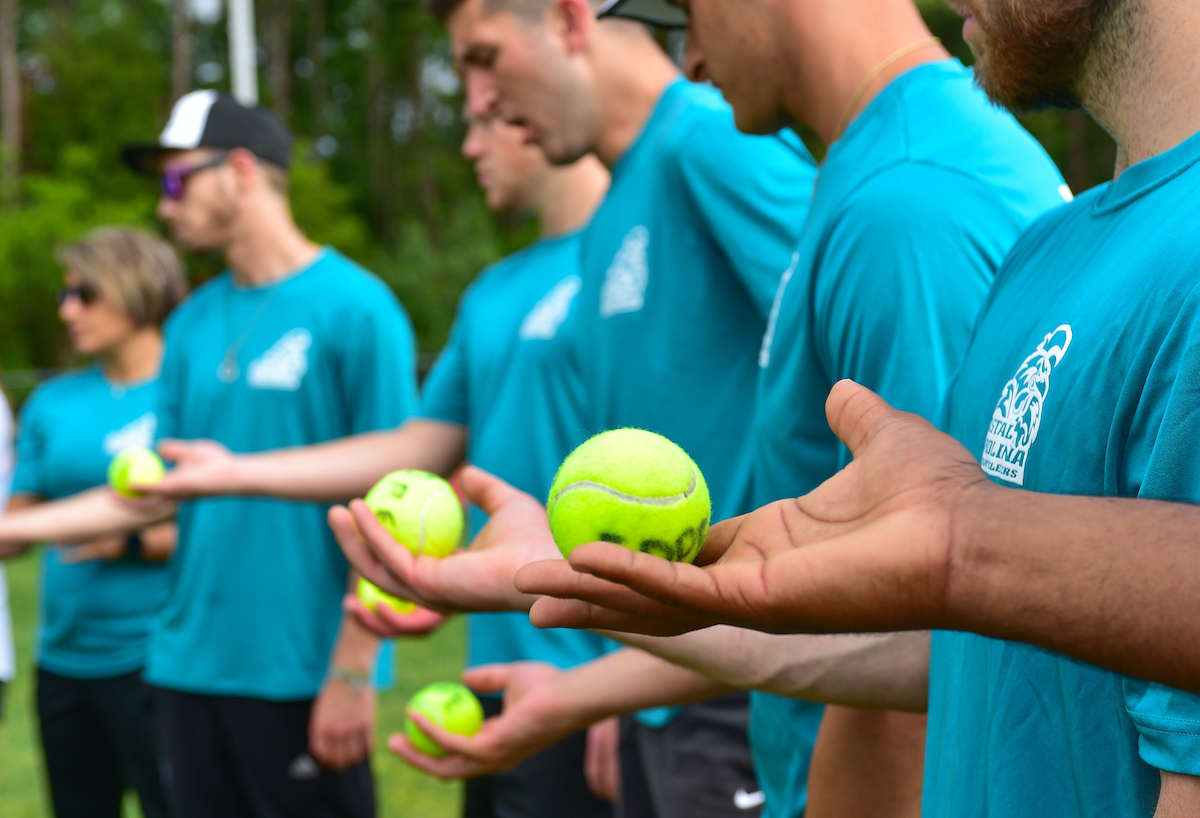 CCU student hands holding tennis balls